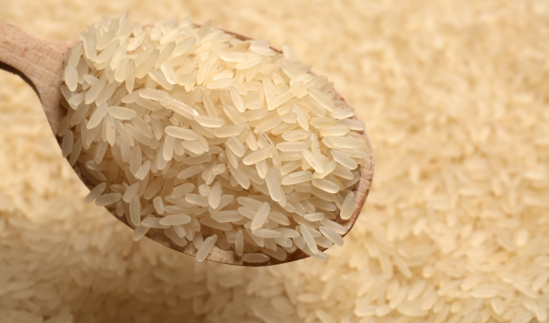 Cuillère en bois remplie de riz long grain – Coséame, grossiste riz Afrique de l’Ouest