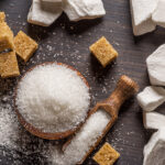 Sucre ICUMSA 45 en grains, morceaux de sucre blanc et sucre brun sur une table en bois