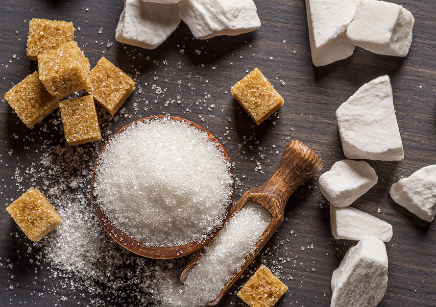 Sucre ICUMSA 45 en grains, morceaux de sucre blanc et sucre brun sur une table en bois