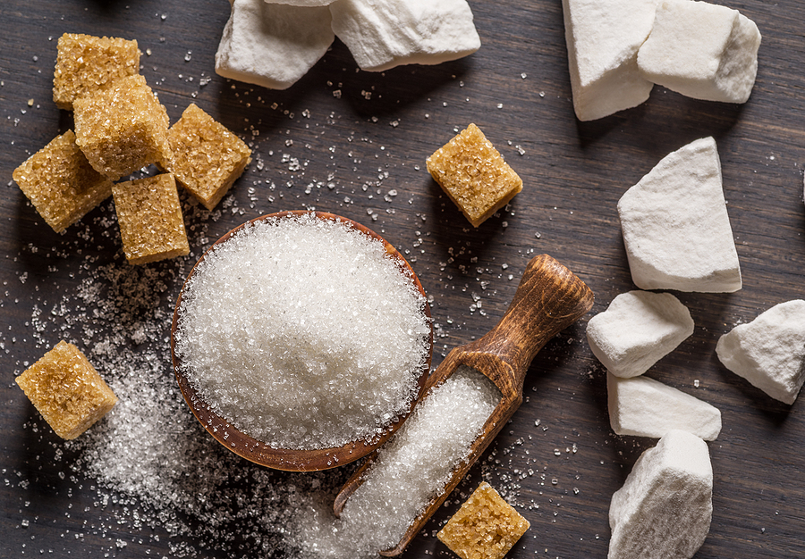 Sucre ICUMSA 45 en grains, morceaux de sucre blanc et sucre brun sur une table en bois